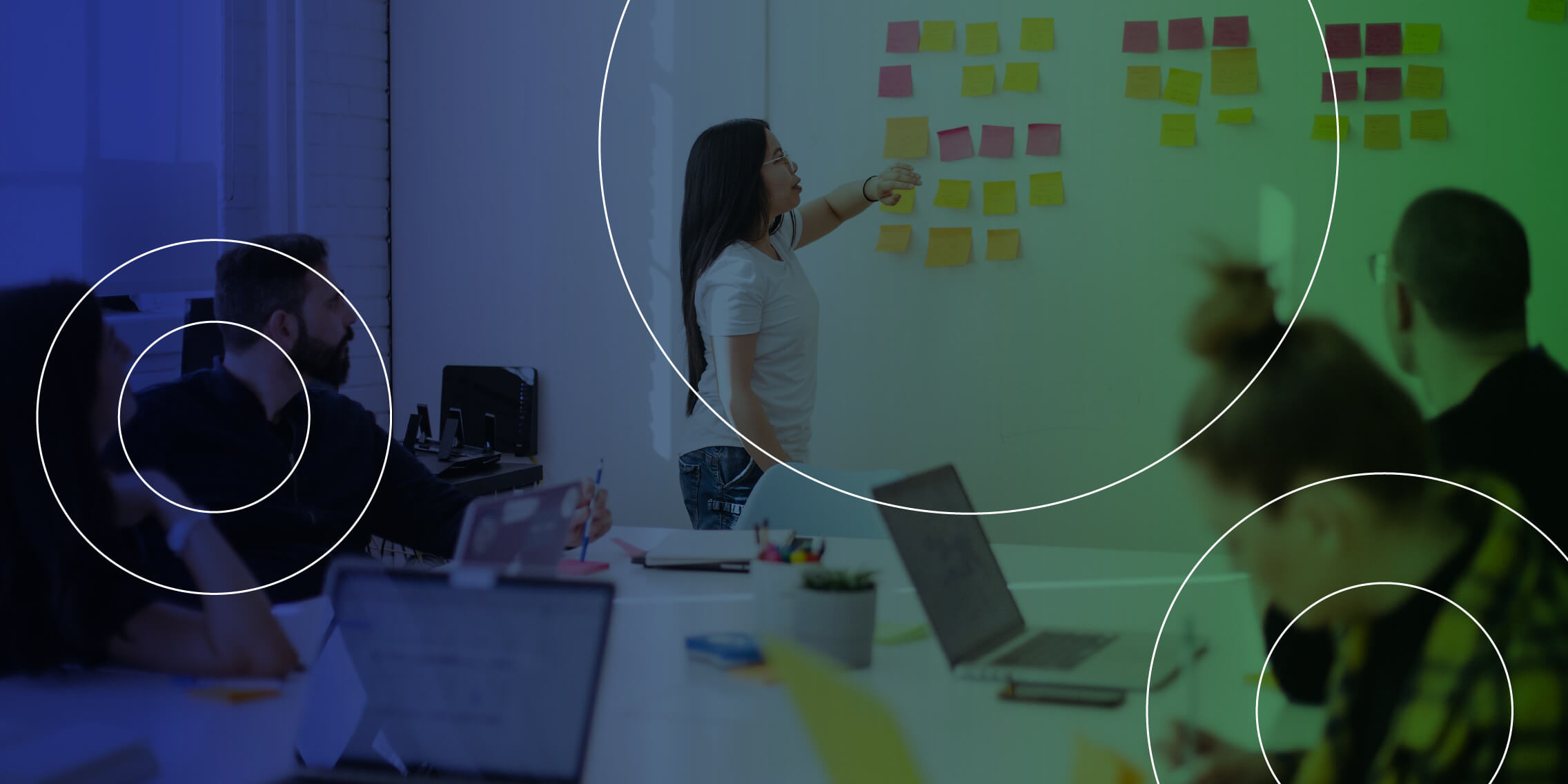 People looking at a whiteboard with post-its.
